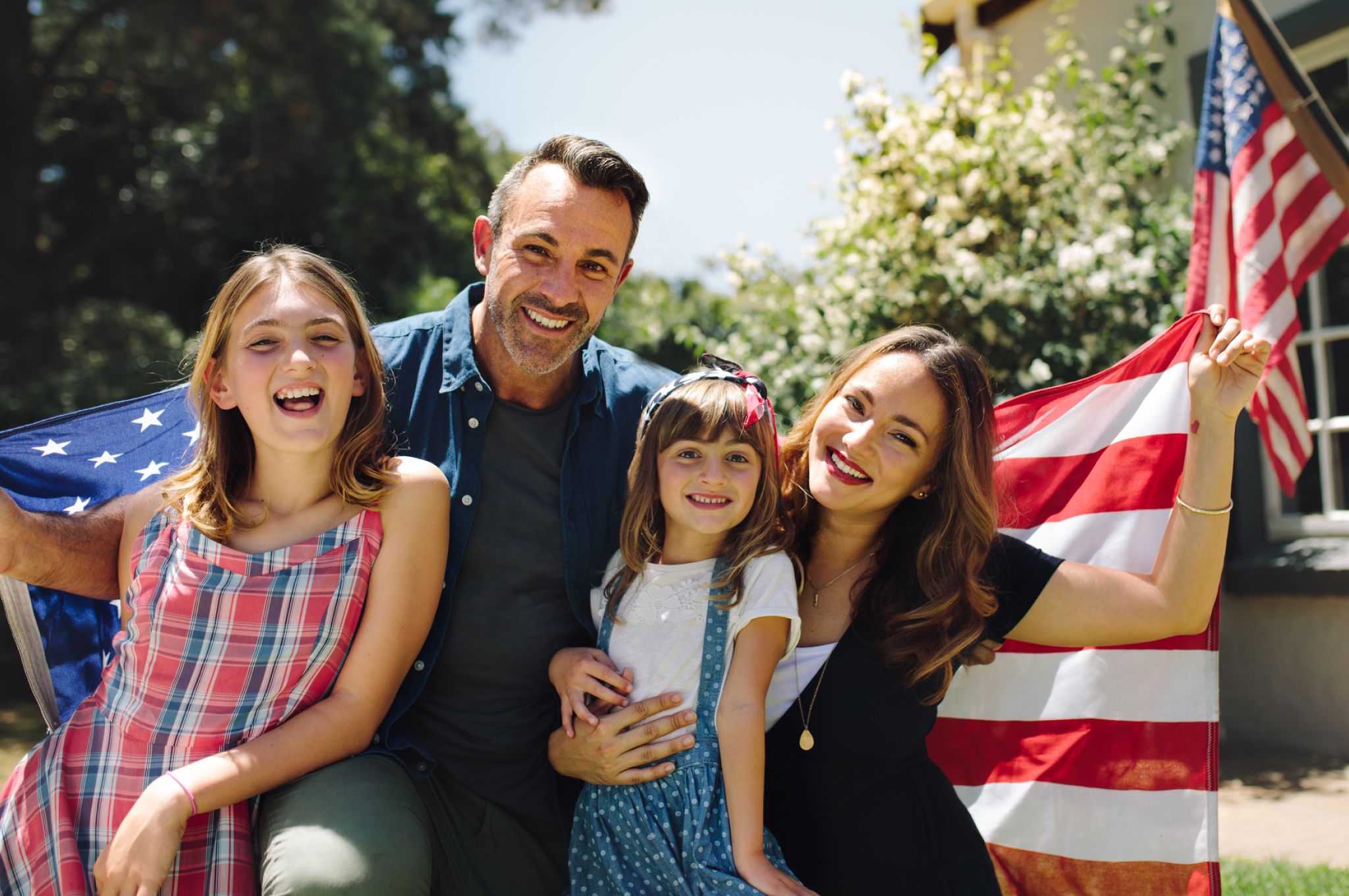 family sitting in front of the american flag